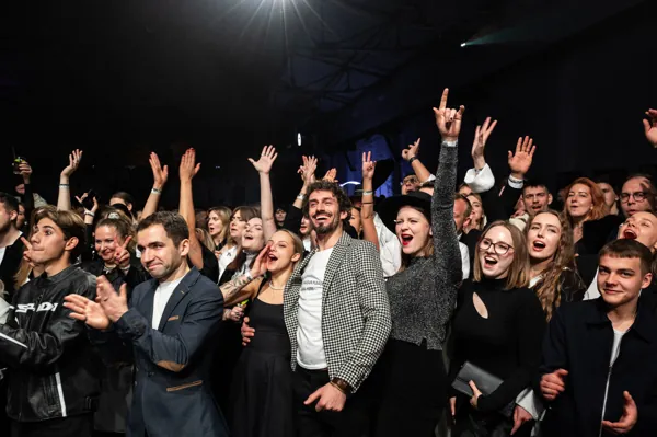 The team cheering with their hands in the air at a company party